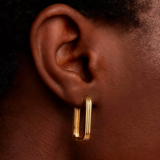 Model wearing gold hoops