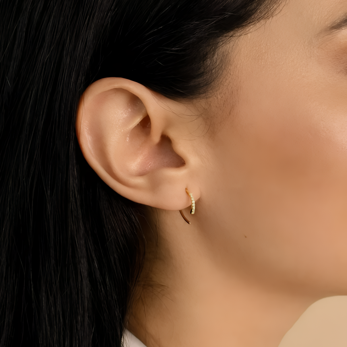 En stilfull kvinne bærer åpne gullbelagte sterling sølv hoops med strålende steiner, perfekte gulle øredobber for enhver anledning. Disse elegante øreringene legger til et snev av glamour til antrekket, og deres tidløse design gjør dem ideelle for både hverdagsbruk og spesielle anledninger