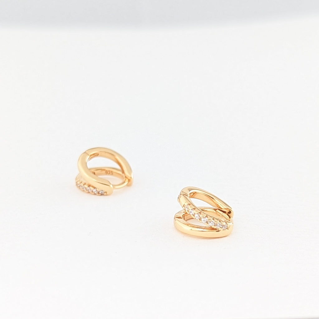 Detaljbilde av gulløreringer med glitrende steiner – Huggie hoops i forgylt sølv fra Artlysian