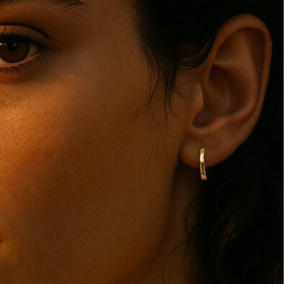 Gold hoop earrings on ear of model