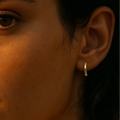 Gold hoop earrings on ear of model